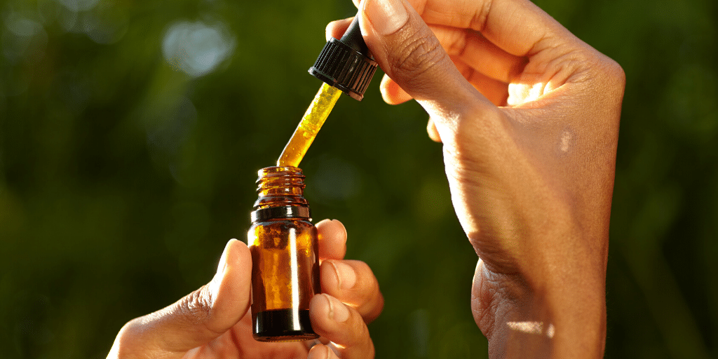 a person pouring a dropper into a bottle
