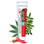 a tube of ointment with red and white label next to leaves and red pepper
