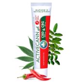 a tube of ointment with red and white label next to leaves and red pepper
